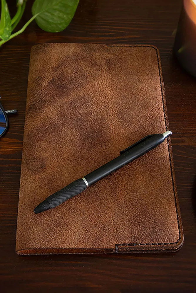 A water buffalo leather Journal with a pen resting on the cover