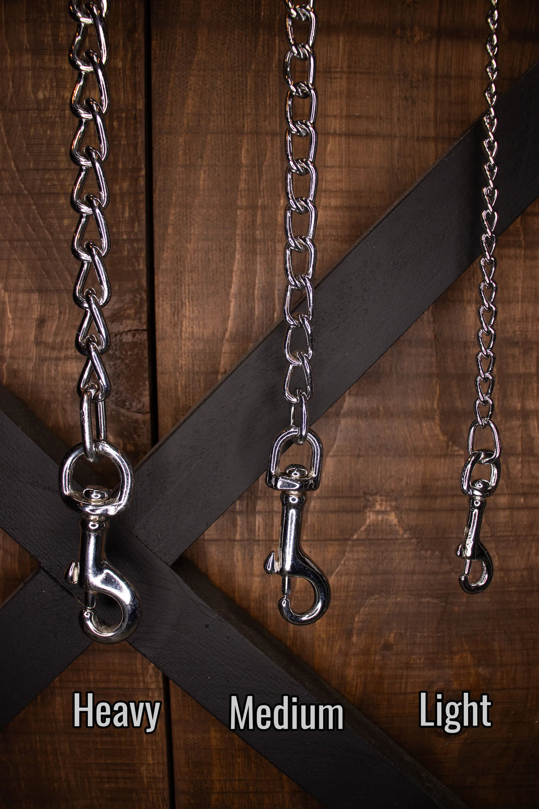 Three chain for leashes labeled 'Heavy', 'Medium', and 'Light' on a wooden background.