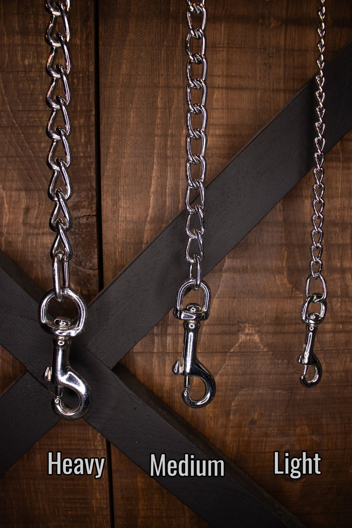 Three chain for leashes labeled 'Heavy', 'Medium', and 'Light' on a wooden background.